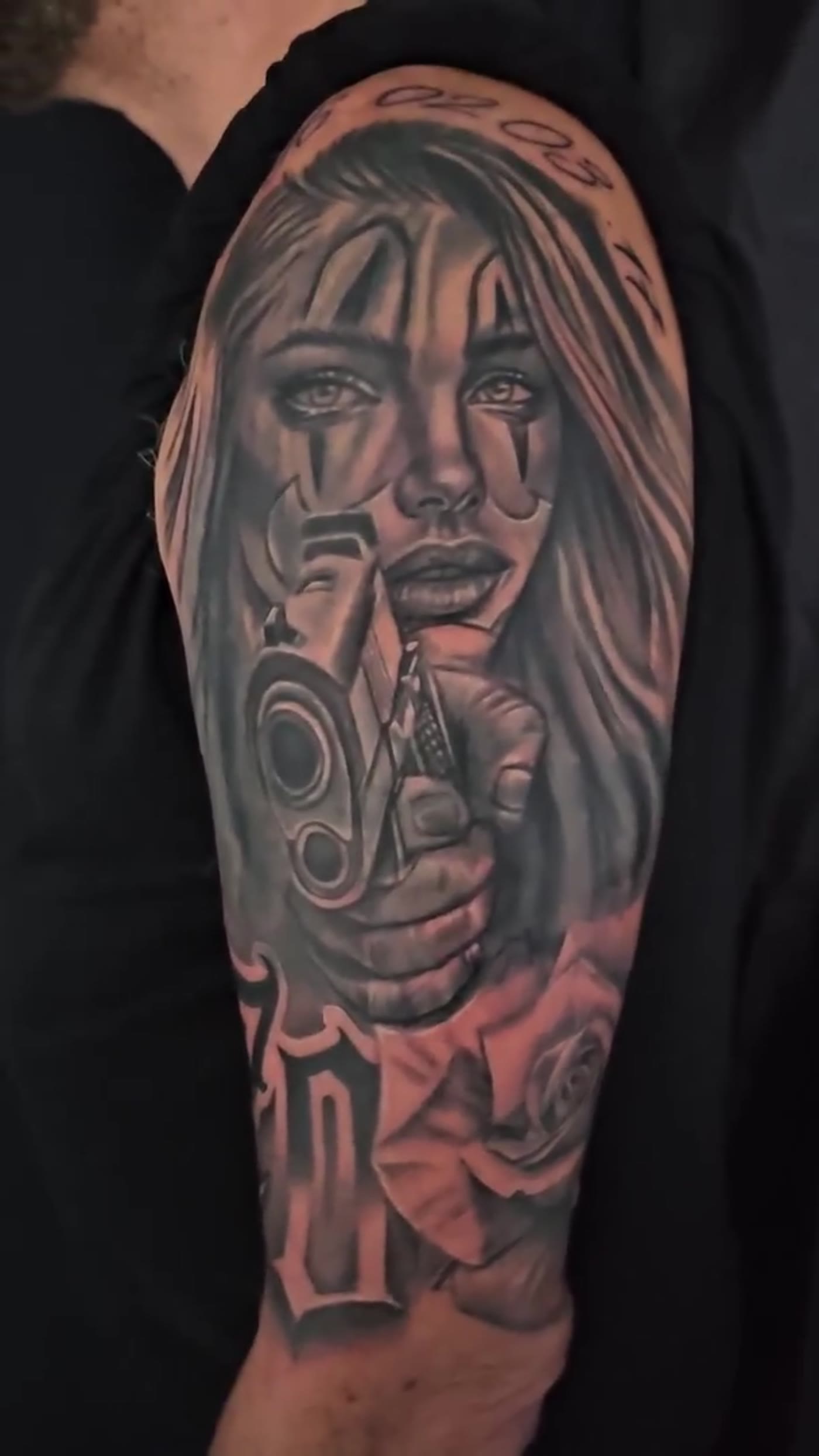 Reworked black-and-grey portrait tattoo on the bicep by Guy Abergel