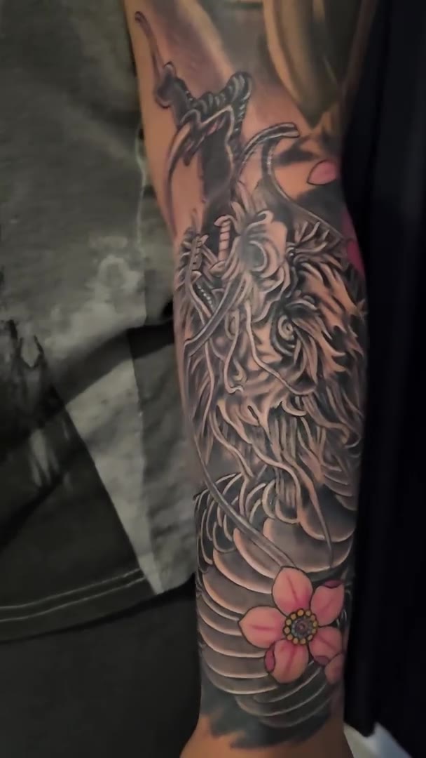 Japanese-style dragon and blossom tattoo on the forearm by Guy Abergel