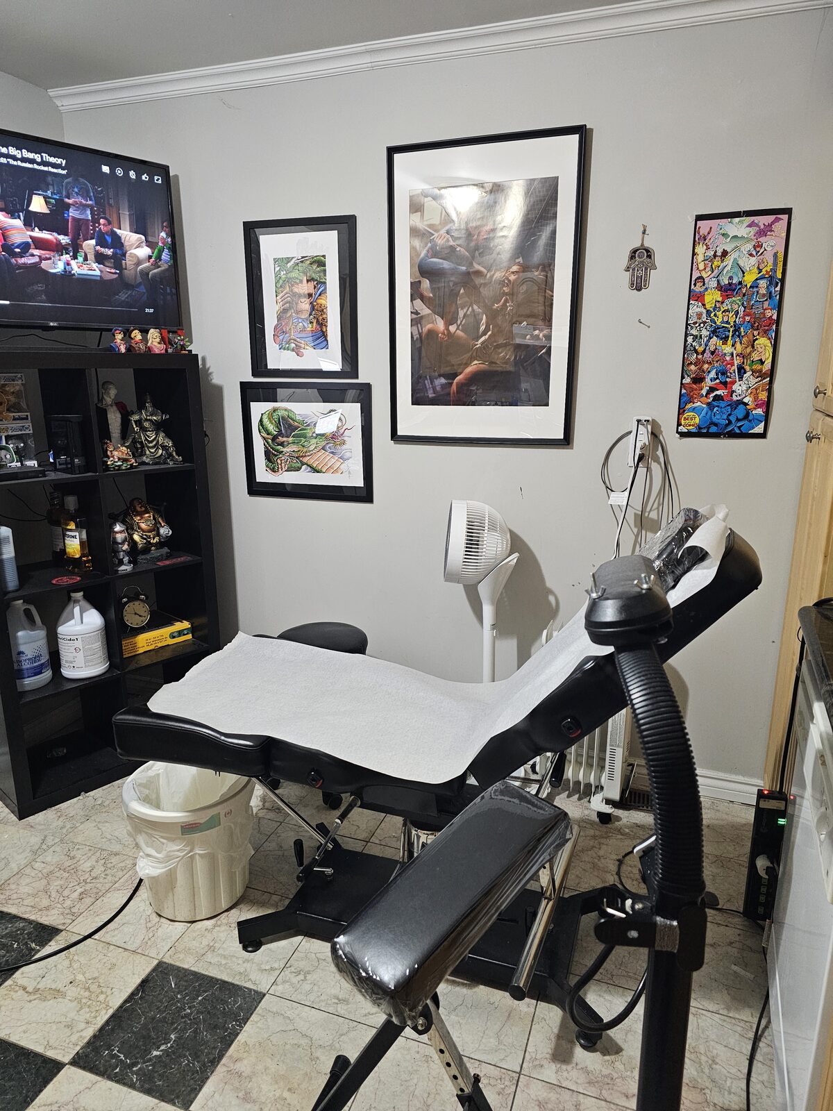 Tattoo station framed by portrait paintings on the studio wall